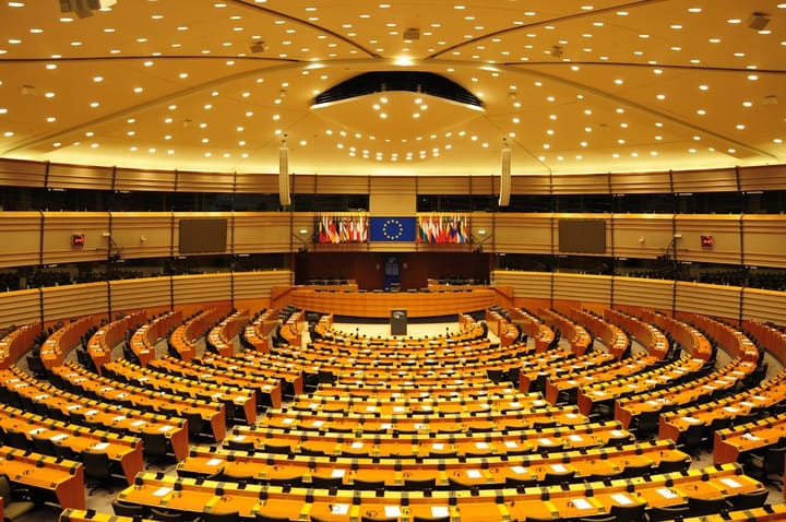 EU leaders discussing the AI Act, surrounded by flags, showcasing a tense atmosphere of collaboration and conflict.